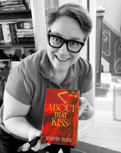 Harper Bliss smiling while holding the About That Kiss Deluxe Edition